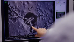 Scientist pointing at microscope screen showing Vigilis bio material biodegrading at BIOME 2021